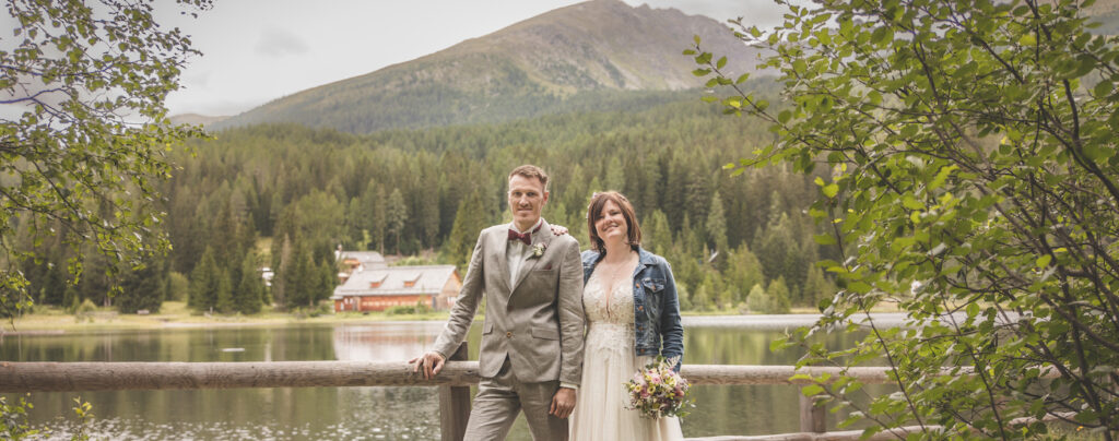 Hochzeit, Hochzeitspaar auf kleiner Brücke vor einem See in den Alpen. Naunhofer Brautpaar heiraten in den Alpen, Ludlalm. Fotograf mit Liebe zum Bild.